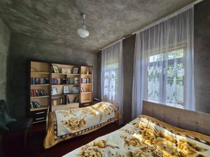 a bedroom with two beds and a book shelf at Maikostan in Shuakhevi