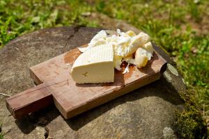 a piece of cheese on a wooden cutting board at Maikostan in Shuakhevi