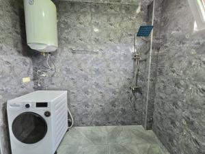 a bathroom with a shower and a washing machine at Maikostan in Shuakhevi