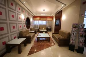 a living room with couches and a table at Tulip Hotel Apartments in Dubai