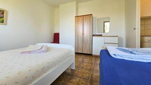ein kleines Schlafzimmer mit 2 Betten und einem Schrank in der Unterkunft Davor 1 in Dajla