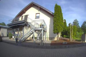 a white house with a staircase on the side of it at Chez Ellie- Ferienwohnung Nähe Nürburgring, Rhein, Ahr, Eifel in Kempenich