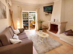 Una sala de estar con un sofá y una chimenea. en Giramar Apartamentos Turisticos, en Lagos
