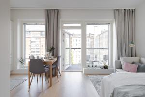 a white bedroom with a dining room table and a bed at Best location, cozy and peaceful in Tampere