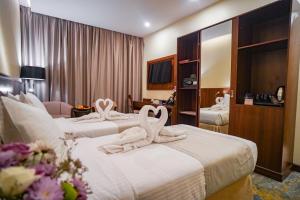 Ένα ή περισσότερα κρεβάτια σε δωμάτιο στο Emaar Elite Hotel