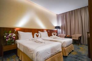 Ένα ή περισσότερα κρεβάτια σε δωμάτιο στο Emaar Elite Hotel