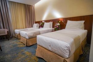 Ένα ή περισσότερα κρεβάτια σε δωμάτιο στο Emaar Elite Hotel