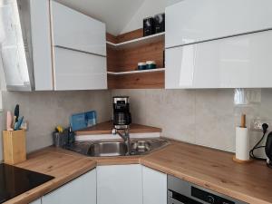 a kitchen with white cabinets and a sink at Apartment Azuri in Okrug Donji