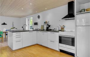 a kitchen with white cabinets and a stove top oven at Holiday Home Sølvpoppelvej Væggerløse Vi in Marielyst