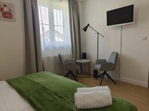 a bedroom with a bed with a television and chairs at Achilla Bed & Breakfast in Český Krumlov