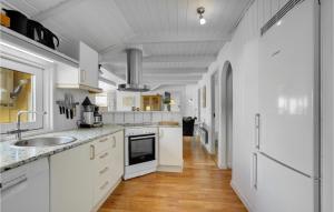 Una cocina blanca con fregadero y refrigerador. en Gorgeous Home In Hejls With Sauna, en Hejls