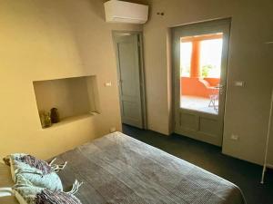 a bedroom with a bed and a door to a patio at Casa Nica, giardino e vista mare in Malfa