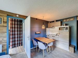 una pequeña cocina con mesa de madera y sillas en Grizzli 23 - appartement - 4 pers - Ski-in-out, en Les Gets 5 fotos más