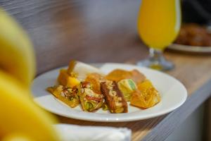 a plate of food on a table with a glass of orange juice at Worth Elite Hotel in Mecca