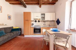 a kitchen and living room with a couch and a table at Residenza il Vicolo del Corso in Massa Marittima