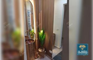 a hallway with a mirror and a potted plant at للايجار ايام الصيف فيلا فاخره بستيلا هايتس - الساحل الشمالي in El Alamein +43 photos