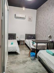Una habitación con tres camas y una mesa dentro. en Triple Room in King Queen Single Bukit Mertajam Alma, en Bukit Mertajam 3 fotos más