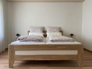 a bed in a room with two pillows on it at Ferienwohnung Waldblick in Trassem