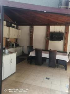 a kitchen with white cabinets and a table and chairs at Casa RAZVAN EFORIE NORD in Eforie Nord