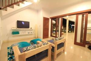 a living room with two chairs and a tv at Villa Alam Biru in Sanur