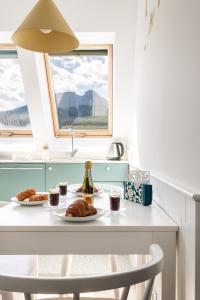 a table with a plate of food and a window at Apartamenty Mikołaj Zakopane in Kościelisko