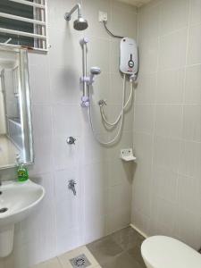 Un baño con ducha, inodoro y lavabo. en Cahaya Qaira Homestay @ D'Perdana Kota Bharu, en Kota Bharu
