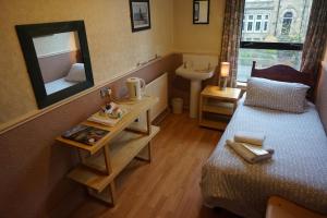 una camera con letto, specchio e lavandino di The Boundary Hotel - B&B a Leeds