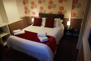 1 dormitorio con 1 cama grande y toallas. en The Boundary Hotel - B&B, en Leeds
