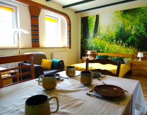 a table with cups and plates on it in a room at Dom Na Wzgórzu in Pollnow