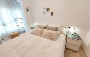 ein weißes Schlafzimmer mit einem großen weißen Bett mit Kissen in der Unterkunft Stunning Apartment In Puerto De Sagunto in Puerto de Sagunto