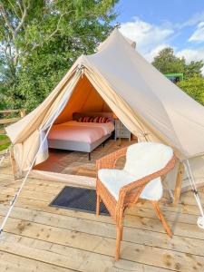 Tenda con letto e sedia su una terrazza di Greystones Glamping - Tent 4 a Greystones