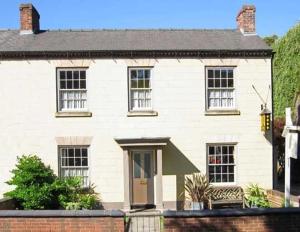 una casa di mattoni bianchi con una porta marrone di The Coach House a Melbourne