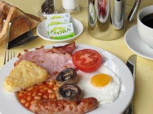 a plate of breakfast food with eggs bacon beans and tomatoes at The Coach House in Melbourne