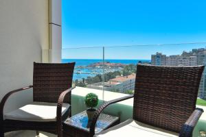 a balcony with two chairs and a view of the ocean at Apartman Drobnjak Center-sea View in Budva