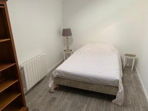 a bedroom with a bed in a white room at La frelonniere in Pontlevoy +2 photos