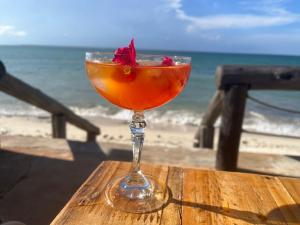a drink in a glass sitting on a table near the beach at R A GUEST HOUSE PEMBA in Pemba