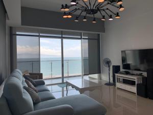 米里Bay Resort Condominium, 7, Beach-front Sea view, 6-8 PAX的带沙发、桌子和电视的客厅