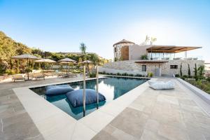 a swimming pool with two blue pillows in front of a house at TERRATORRE in Kefalos