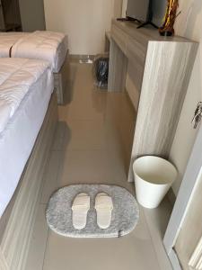 a pair of white shoes sitting on a rug next to a bed at Rent Studio2 full furnished in Jakarta