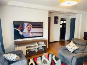 内罗毕Little heaven in ruaka的客厅墙上有一台平板电视