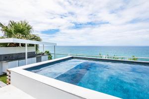a swimming pool with the ocean in the background at Villa Océan vue époustouflante! in Le Gosier