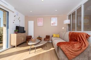 a living room with a couch and a tv at Le Nid Bleu in Ploemeur