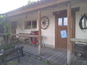 a front porch of a house with a wooden door at Charmantes Western-Zimmer mit Veranda auf dem Raihof in Nenzlingen