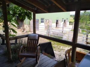 a rocking chair sitting on a porch in front of a barn at Charmantes Western-Zimmer mit Veranda auf dem Raihof in Nenzlingen +2 photos