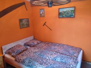 a bed in a bedroom with an orange wall at Charmantes Western-Zimmer mit Veranda auf dem Raihof in Nenzlingen