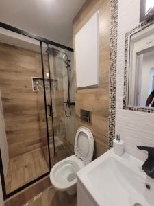 łazienka z toaletą, prysznicem i umywalką w obiekcie Apartament Centrum - Aleja Świętego Jana Pawła II w Kołobrzegu