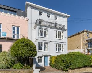 a white building with a balcony on top of it at Cliffhanger 18 Castle Road in Cowes