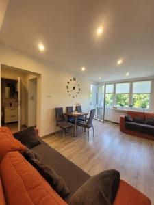 salon z kanapą i stołem w obiekcie Apartament Centrum - Aleja Świętego Jana Pawła II w Kołobrzegu