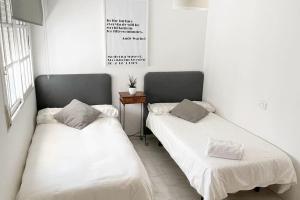 twee bedden naast elkaar in een kamer bij Apartamento Céntrico en O Grove in O Grove
