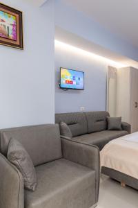 a living room with a couch and a tv on a wall at Villa Kale in Sarandë